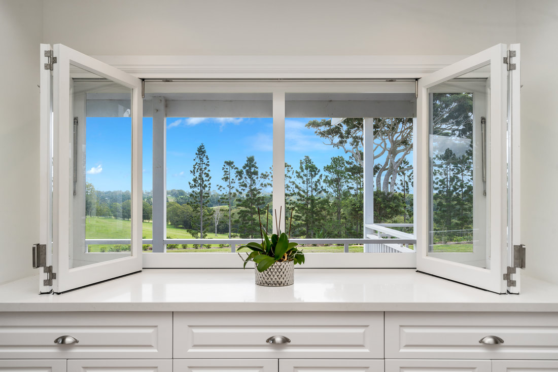 Timber bifold windows opening onto farmland