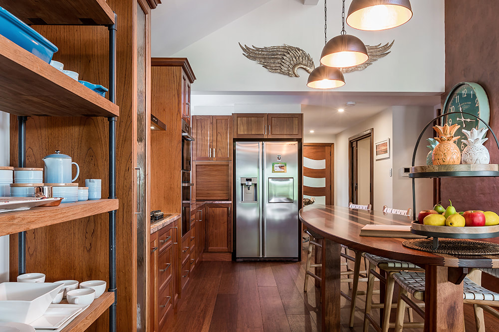 A rich timber kitchen with open shelving and a stone benchtop